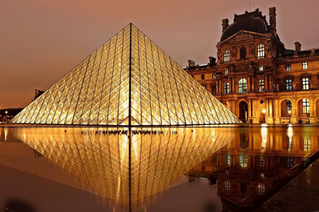 famous louvre museum by night with parisian architecture