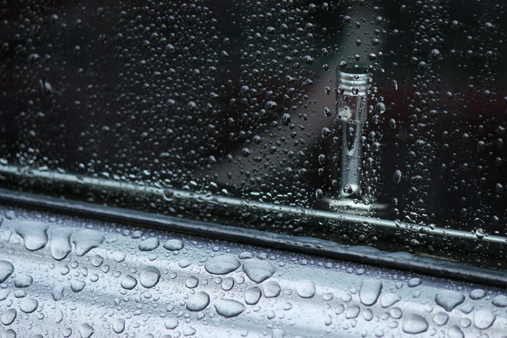 Vintage car window and lock with rain drops