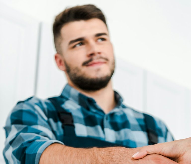 selective focus of woman shaking hands with handyman