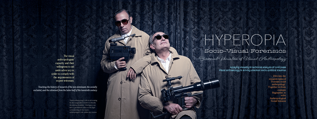 Two men wearing dark sunglasses and beige cotton coats. One is sitting with a large camera in his hands. The other is standing, leaning against him, also holding a large camera. Behind them hangs a black theater curtain with an embossed floral pattern. On either side of the two men, there is text in English in various fonts and colors about 'Hyperopia. Socio-Visual Forensics.'