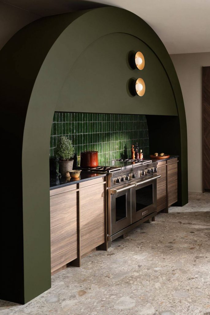 a contemporary kitchen with a deep olive green hood as the focal point, seamlessly blending industrial aesthetics with modern design