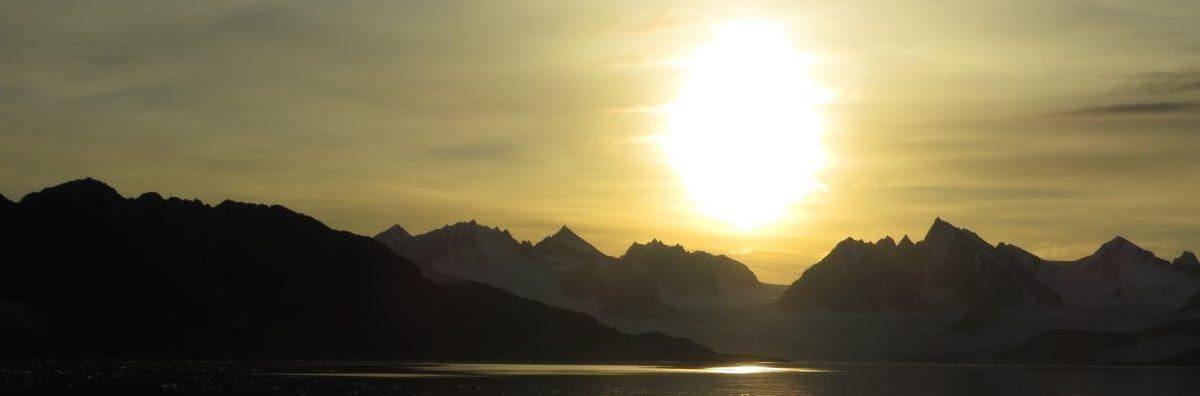 Picture of the midnight sun during summer over a fjord; north-western Svalbard. By Eike Stübner