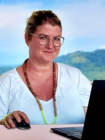 Katja Chaineux beim Coaching an ihrem Laptop vor einem Landschaftspanorama in Costa Rica