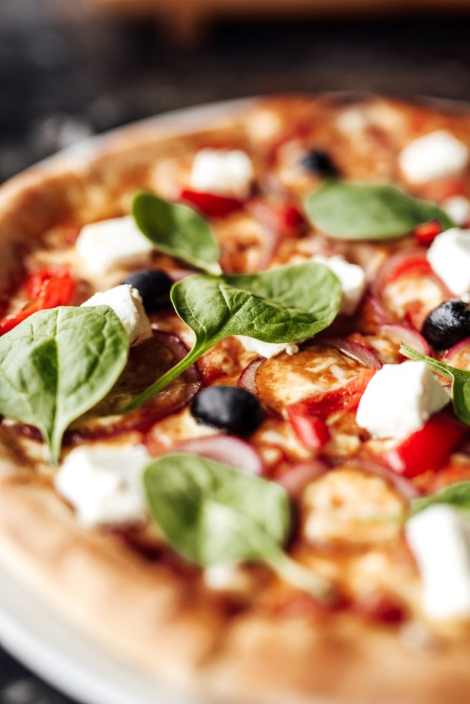 Pizza with with cheese, olives and herbs