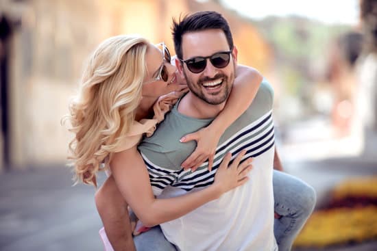 Couple having fun.Man giving piggyback ride to woman in the city.