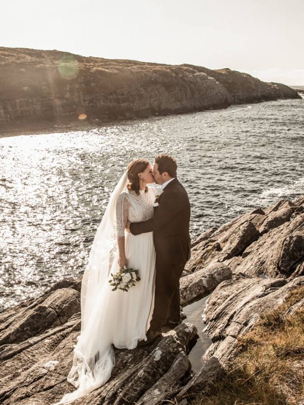 Hege og Roy kysser. De står på en klippe langs havet, langt ute på sotra. Det er sol og vind.