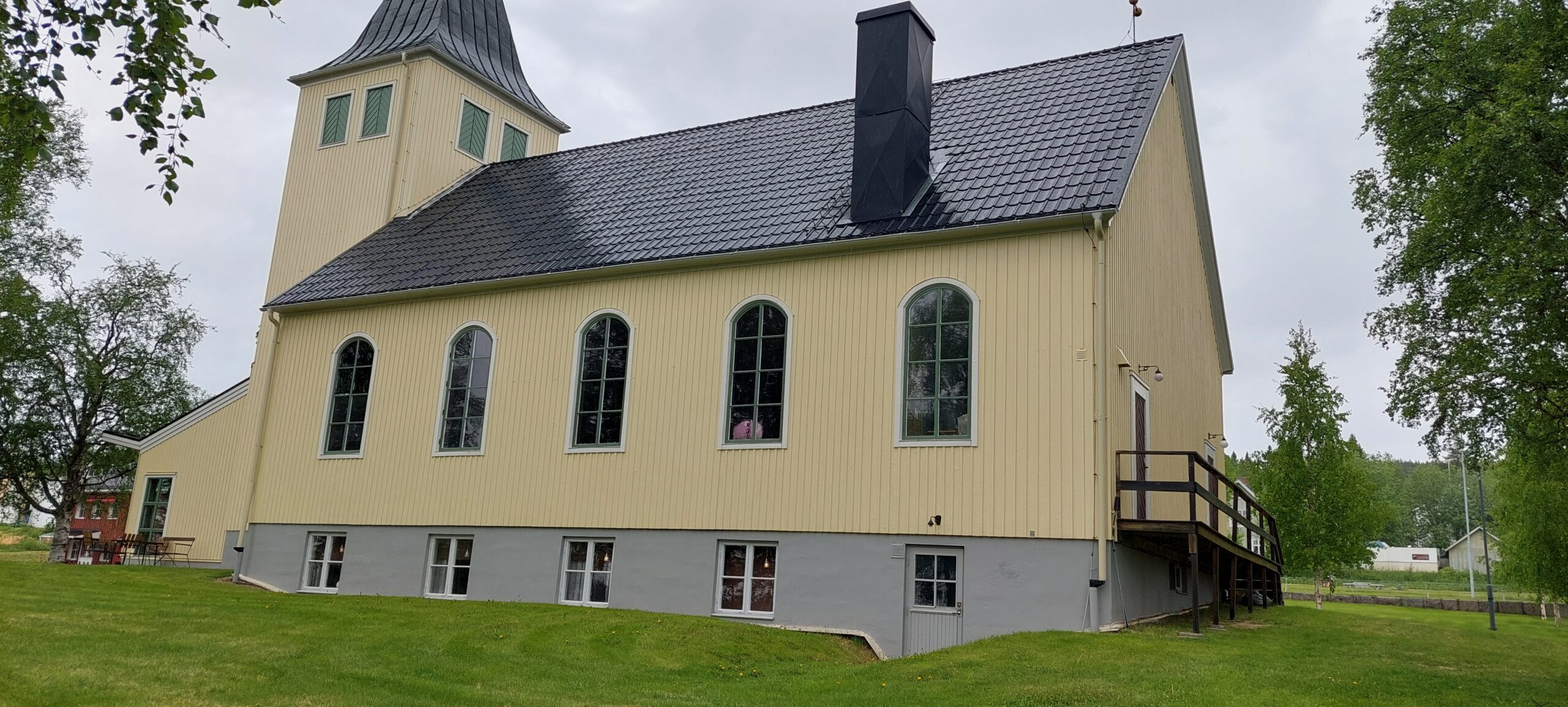 Gul kyrkobyggnad i grönt landskap
