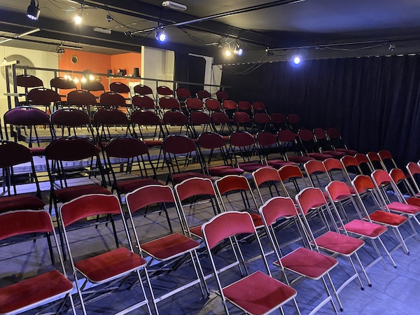Des chaises rouges en gradin dans une salle en location à Etterbeek