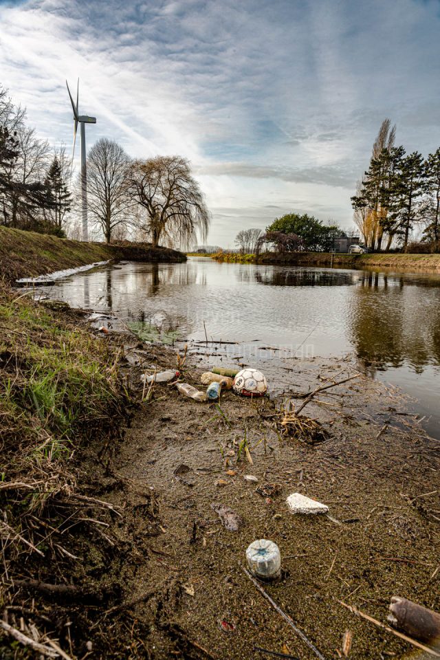 Litter wash up against the bank of the river Avrijevaart in Evergem, Flanders, Belgium