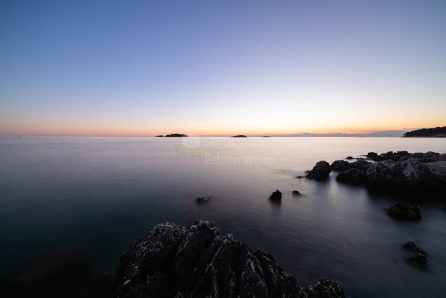 Some islands in a hazy sea after sunset in Funtana, Croatia