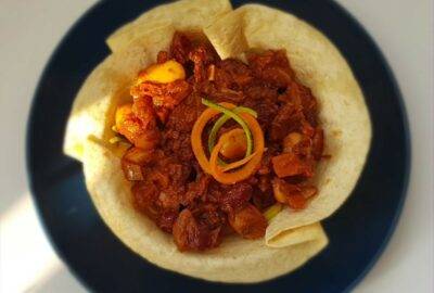chilli in a tortilla bowl on a navy blue plate