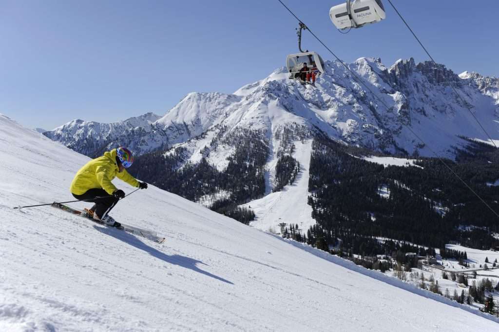 person in yellow coat skiiing