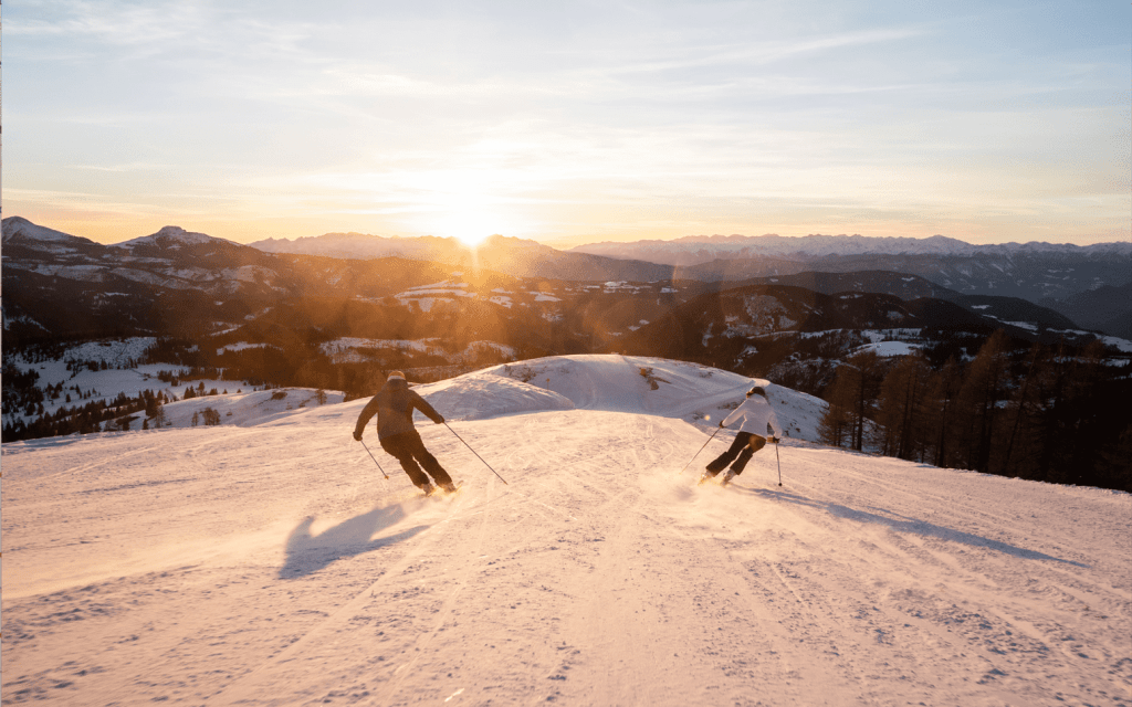 two people skiing during sunset