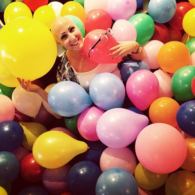 En glad och lycklig Lilian Botvalde i ett färgglatt ballonghav