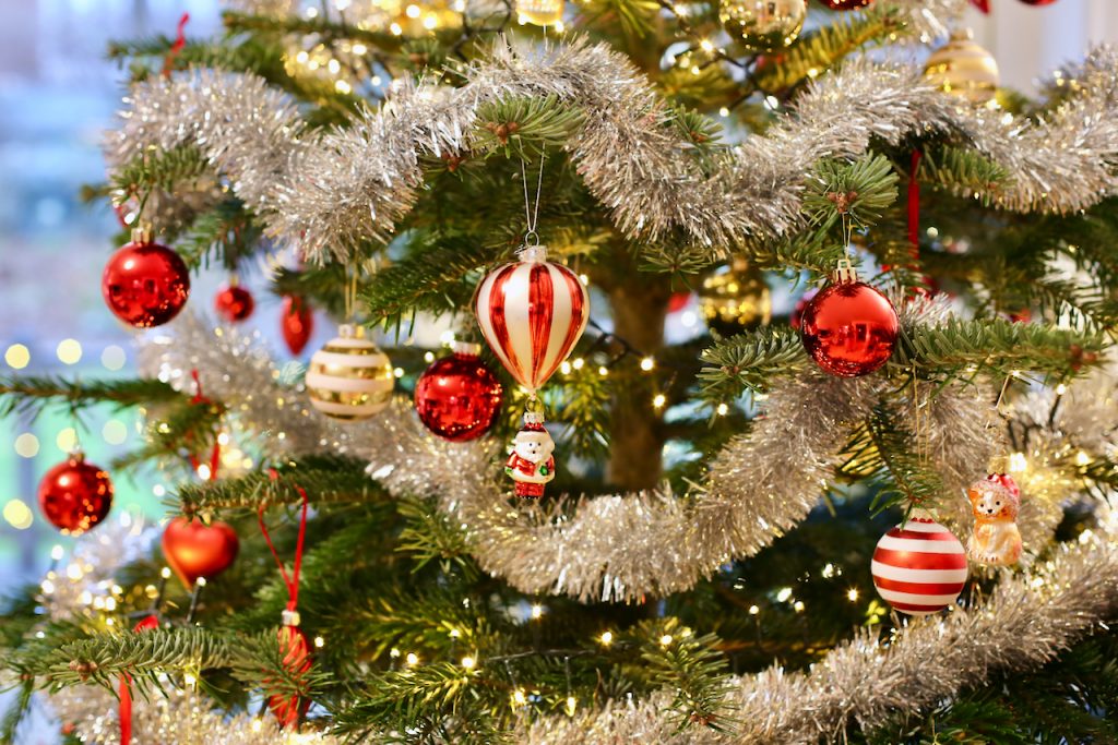 Close up of a decorated Christmas tree in classic style with red and gold ornaments. Photo by Mihaela Limberea