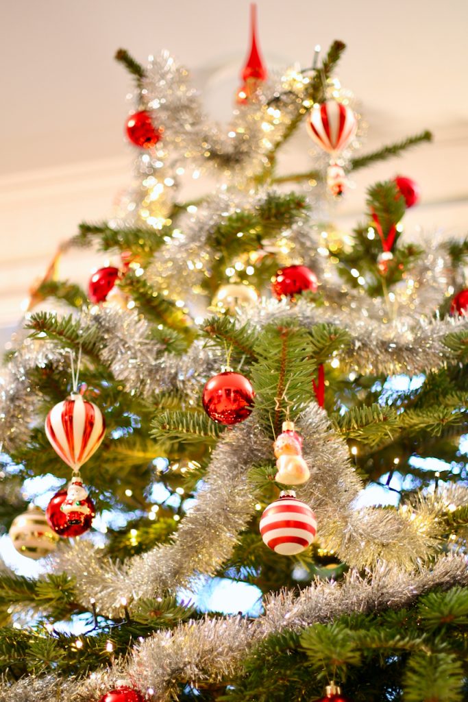 Close up of a decorated Christmas tree in classic style with red and gold ornaments. Photo by Mihaela Limberea