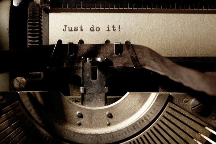 Close up of a vintage-style typewriter with the words "Just do it" typed on the page.