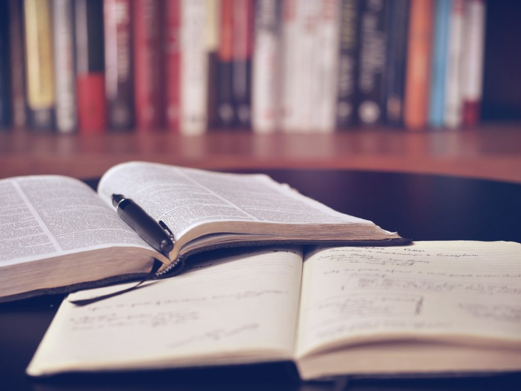 A book and a notebook on a desk. 