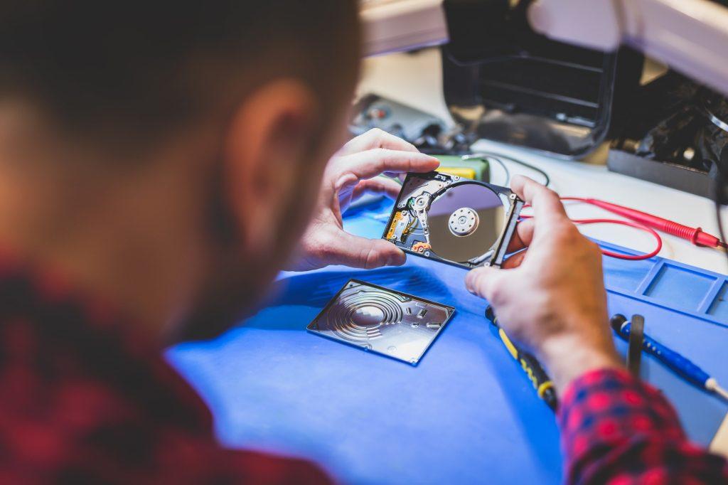 Man repairing hard disk at workplace