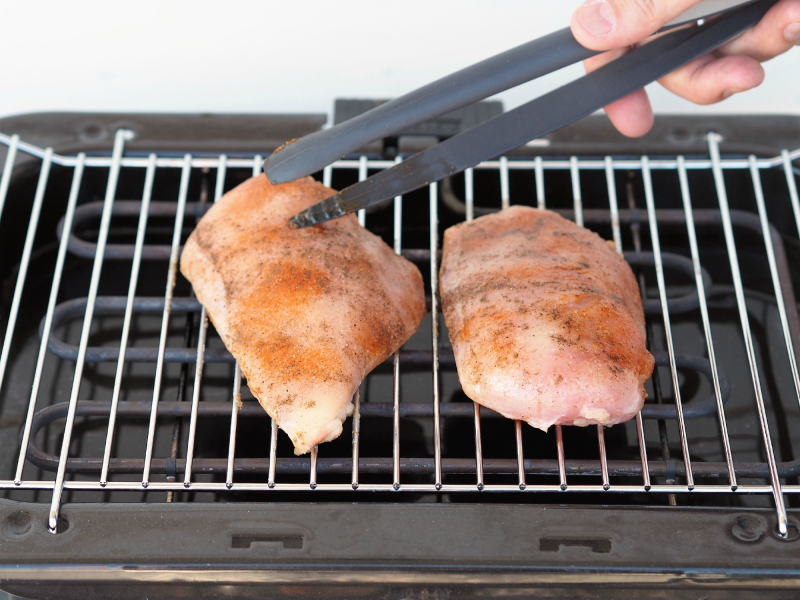 Bilde av to kyllingfileter som steker på grillen, og som skal bli til kylling med tagiatellepasta og kremet chilisaus