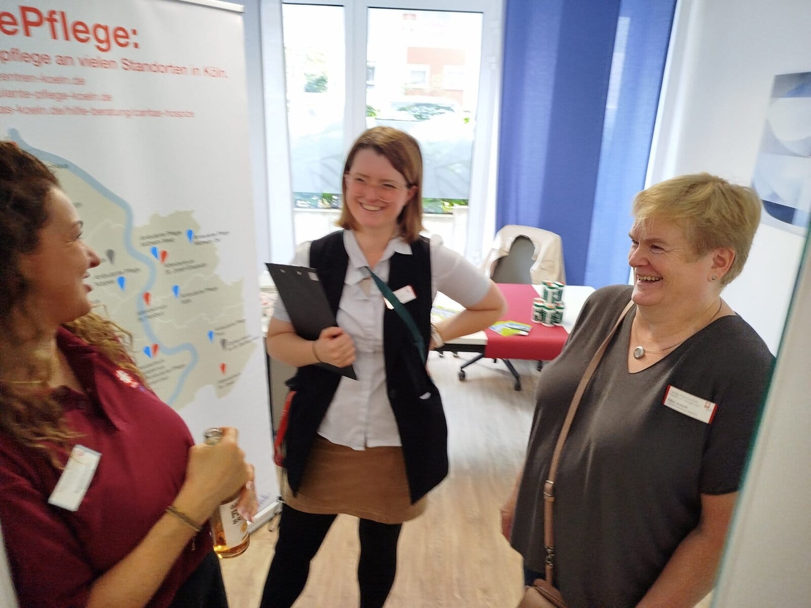 Fachgespräch mit pflegekräften bei lindweiler pflegeheim in köln, freundliches gespräch, fröhliche gesichter, soziale pflegearbeit, pflegepersonal im austausch, professioneller kundenservice.