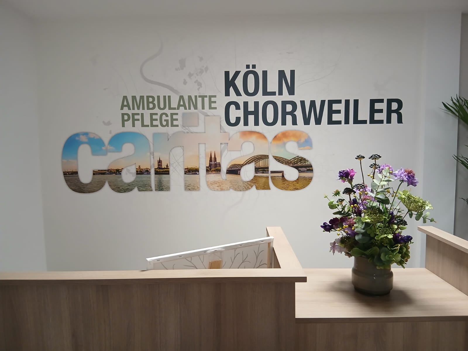 Köln Chorweiler Empfangstresen mit Blumendekoration, moderne Einrichtung und Willkommensatmosphäre im Gesundheits- und Pflegedienst.