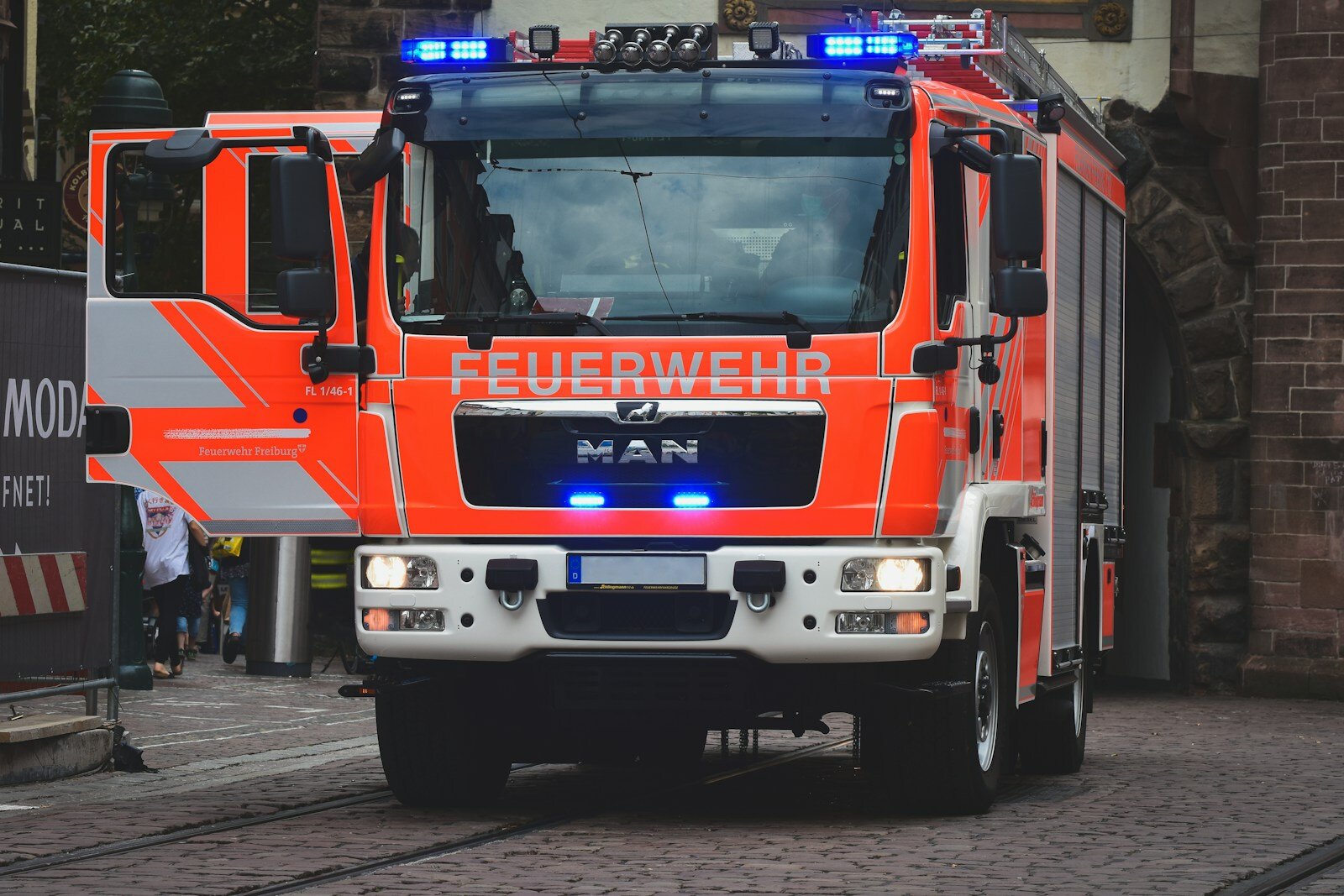 Feuerwehrfahrzeug in rot mit blauen Blaulicht am Einsatzort.