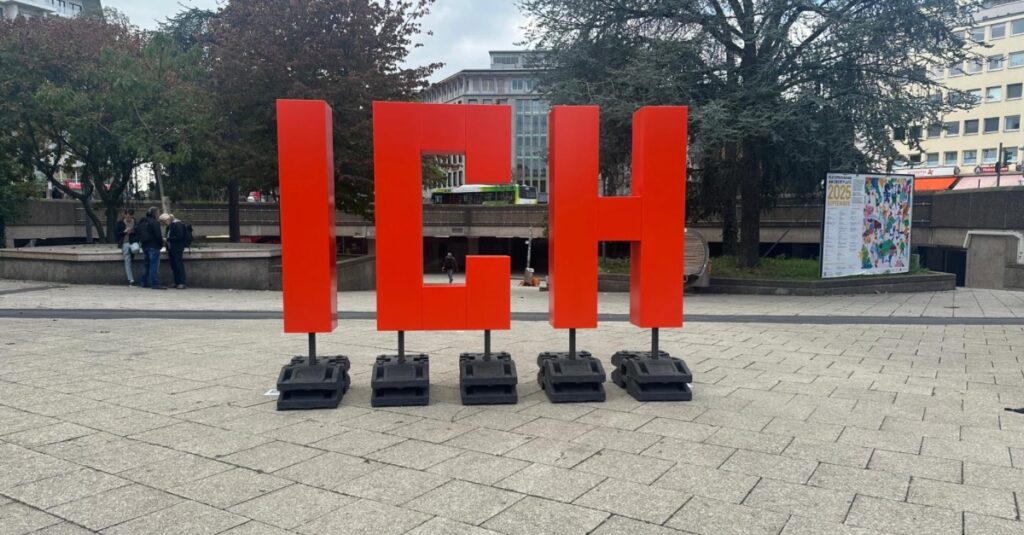 Großes rotes IH-H logo auf einem öffentlichen Platz in Berlin, Deutschland.