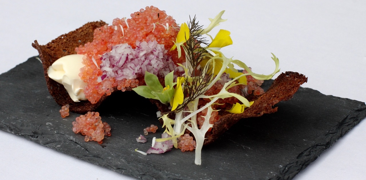 Frisk stenbiderrogn på sprøde brød med creme fraiche og rødløg