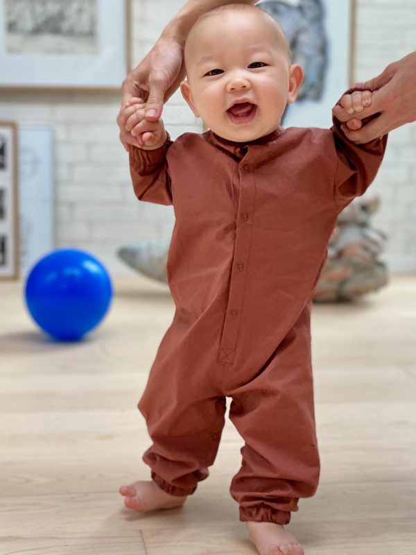 Baby i brun dragt og en blå ballon