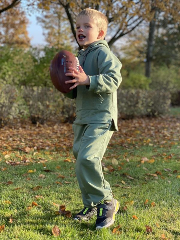 Boy in green jogging suit with football