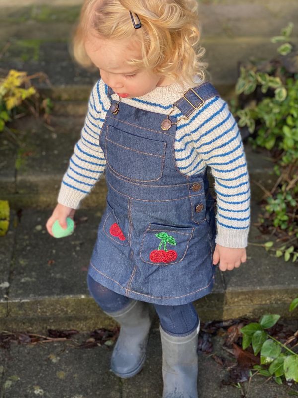 Girl in blue denim Spencer with cherrys on front pockets