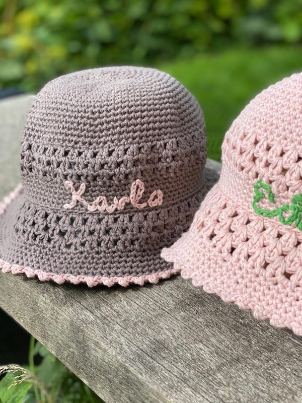 crochet sun hat in brown and light rose on a wooden plank