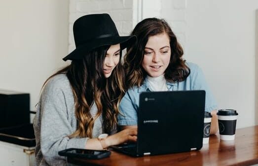 Image of two girls in front of a laptop.