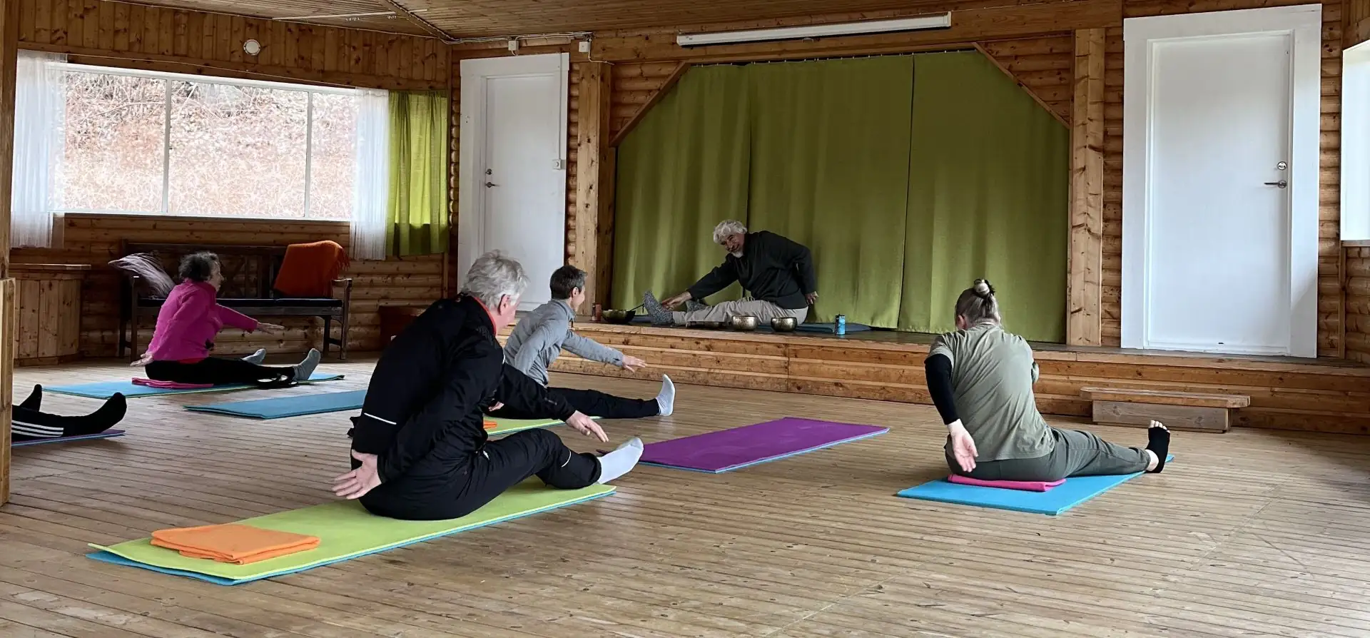Män och kvinnor som gör yoga i rotundan under retreat i Blekinge på Ljuvadal camping.
