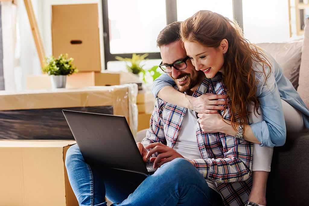 Young couple moving in new home. Sitting and relaxing after unpacking.