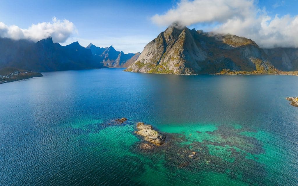 Exclusive small-group sea kayaking in Reinefjord, Lofoten; rugged peaks, guided coastal voyage for up to 8 guests.