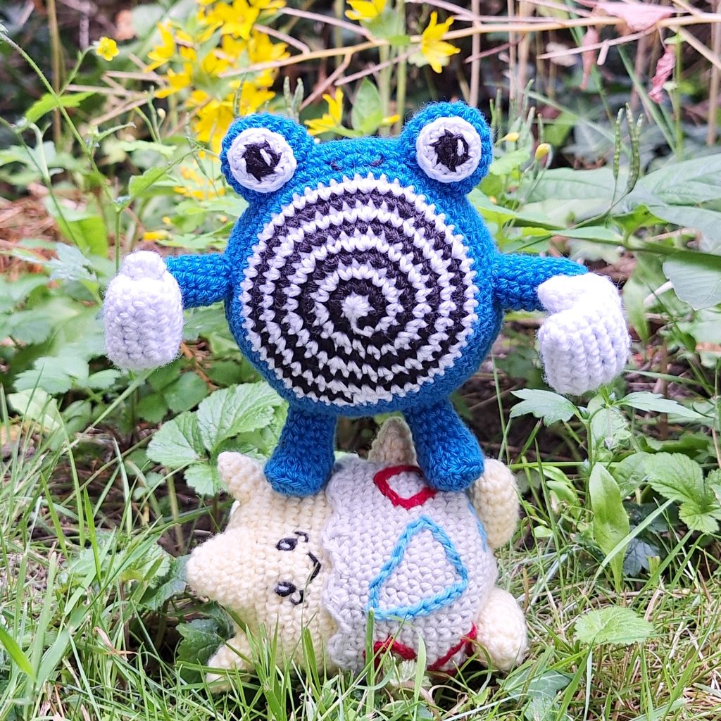 Poliwhirl standing on Togepi to show dominance (crochet pattern)