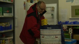 A man stocks the food bank with butter