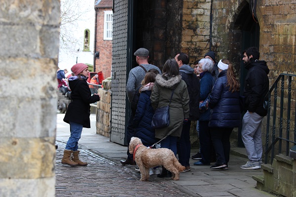 Dog stands with owner on guided tour