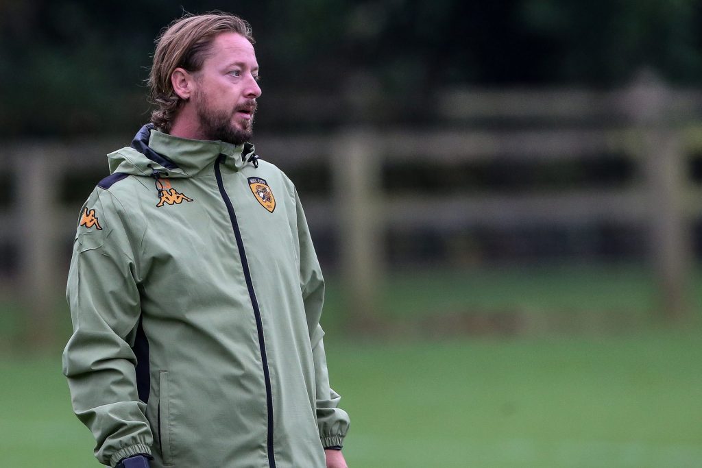 A photograph of Conor Sellars, Hull City Under-21s manager, watching the warm-up of a Hull City Under-18s match against Millwall Under-18s in September 2024.
