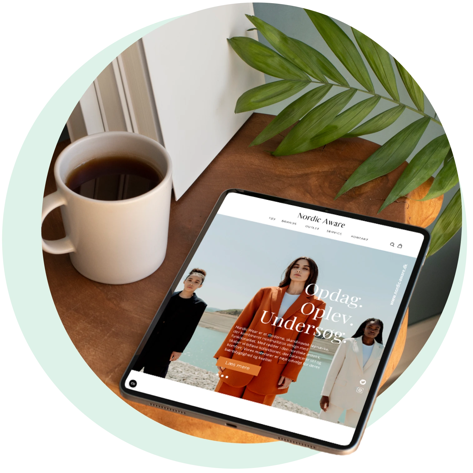 Billedet forestiller et hjemmeside design vist på den ipad, der ligger på et bord