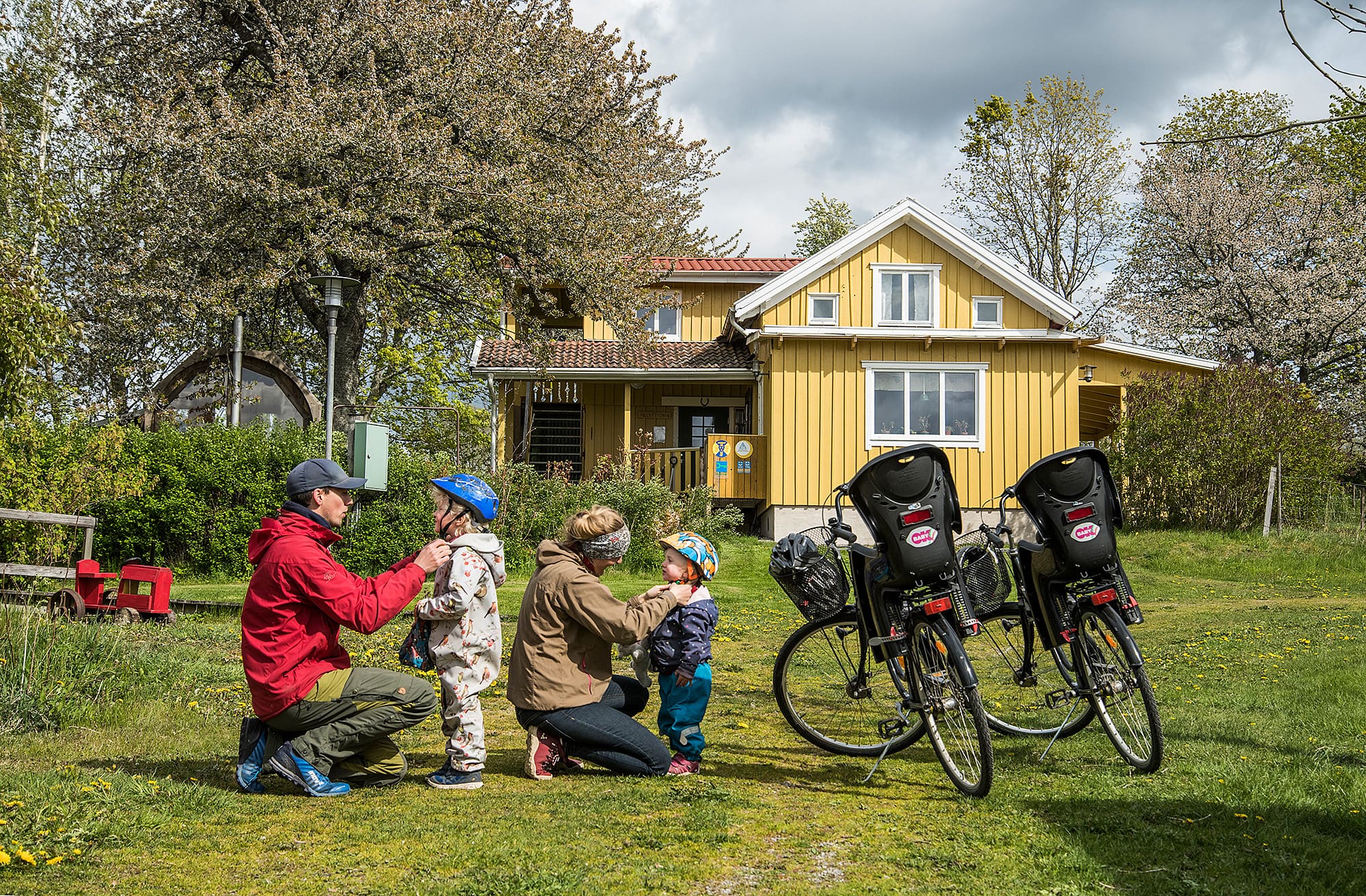 Familj som förbereder sig för cykelsemester med två hyrda cyklar med cykelbarnstol