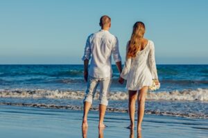 couple se tenant la main sur une plage