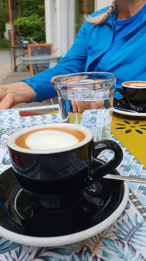 Kafeehalle Semmering. Kaffee in der Tasse, im Hintergrund eine Person .