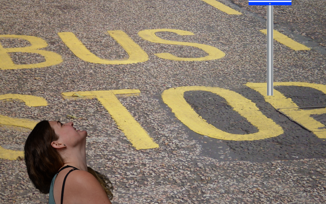 Lydia schaut nach oben auf das Busstopp-Schild