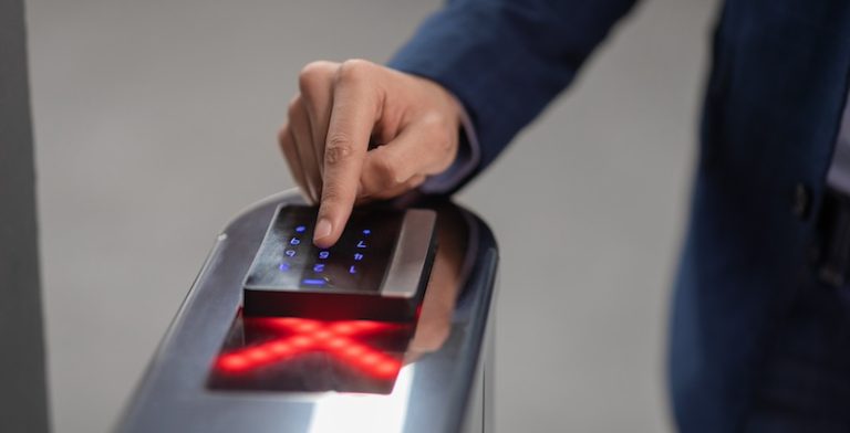 Hand of unrecognizable man in formal outfit employee entering security code while passing building security system at office, panorama with copy space, closeup shot, cropped