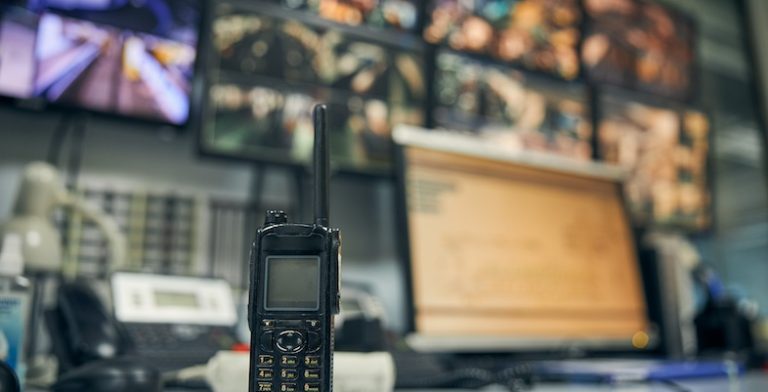 Close-up photo of a walkie-talkie sitting on an office desk in a security control room