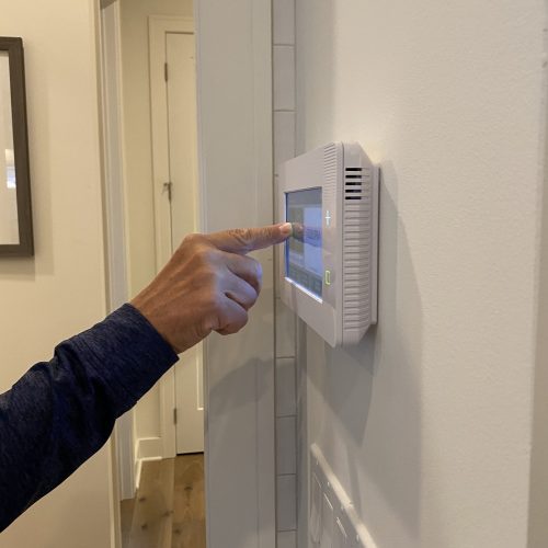 a-man-is-setting-his-alarm-on-a-security-panel-in-his-smart-home-.jpg