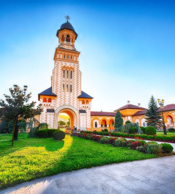 The Coronation Orthodox Cathedral and Roman Catholic cathedral in Fortress of Alba Iulia. Dramatic summer scene of Transylvania, Alba Iulia city, Romania, Europe